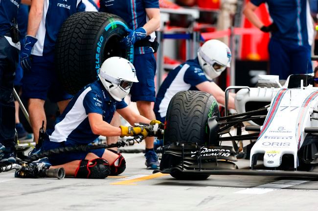 Kru tim Williams F1 sedang mencopot ban dengan wheel gun